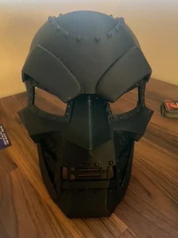 Svart cosplayhjälm med paneler och öppningar sedd framifrån