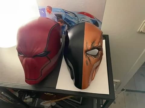 Två målade cosplaymasker i rött samt orange och svart